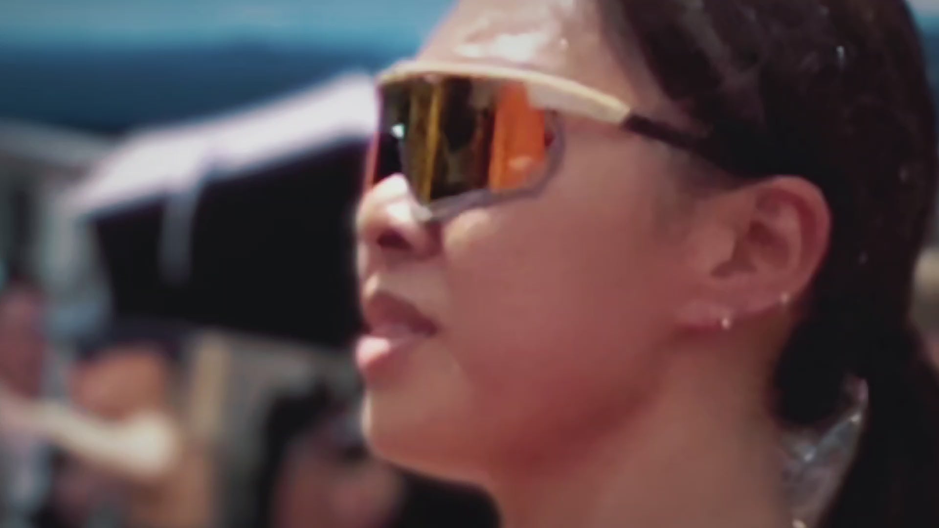 Load video: Athlete wearing polarised high contrast orange mirrored lens with cream carbon fiber frame. 